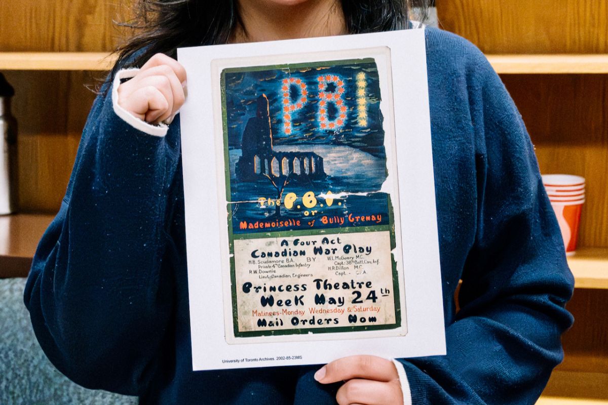 A student curator holds a playbill from P.B.I.