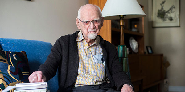 Rev. Gordon Toombs at the age of 101 seated on a blue couch.