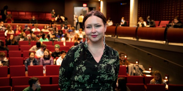 Liz Howard standing in front of a crowd at the Isabel Bader Theatre.