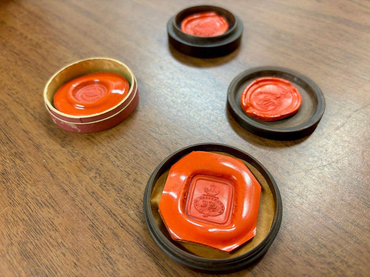 Orange wax seals with a crest imprinted in them.